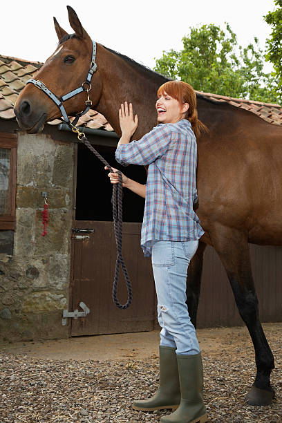 istock Woman With Horse Outside Stable 531026409