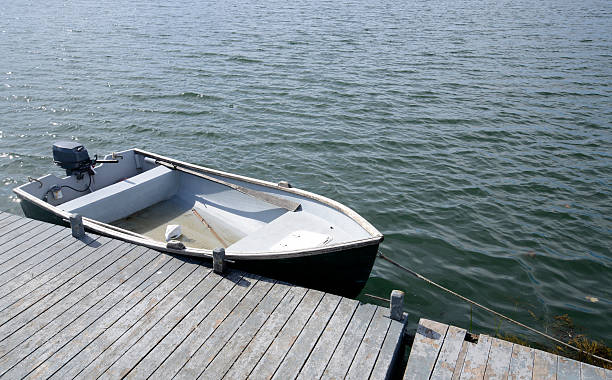 rowboat by a wood pier stock photo