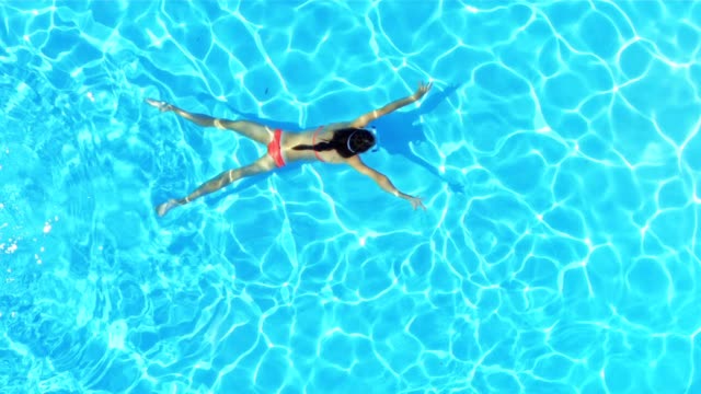 SLO MO Girl swimming underwater across a pool