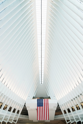 New York City, USA - May 7, 2016: Inside the Oculus. American Flag inside the main hall of the new Oculus, the  World Trade Center Transportation Hub: The World Trade Center Transportation Hub is the Port Authority of New York and New Jersey's name for the new PATH.  Lower Manhattan, New York City, USA.