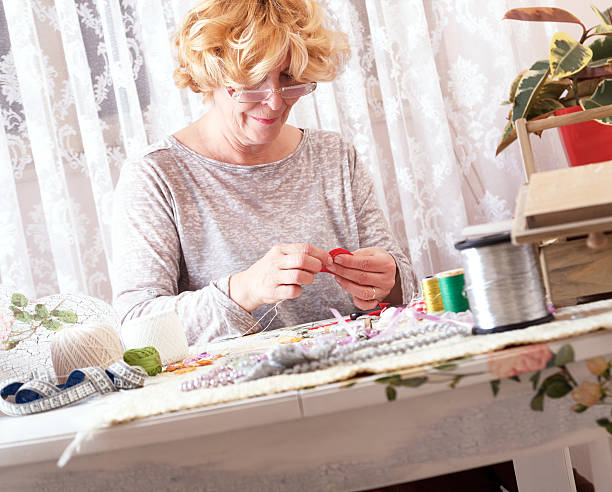 istock Senior women sews by hand 531044397
