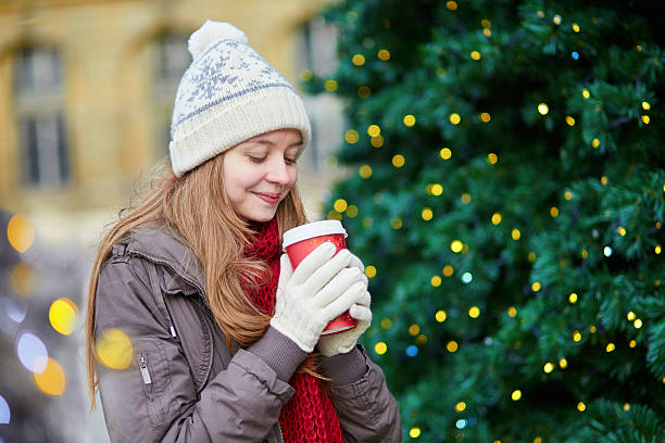 istock Girl drinking coffee near decorated Christmas tree 531044986