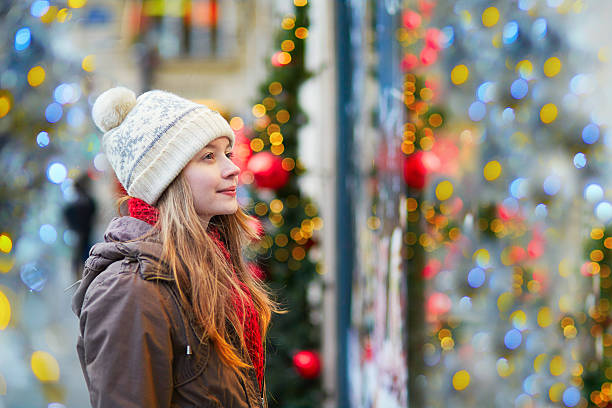 Girl at Christmas market Girl on a Parisian street or at Christmas market looking at shop windows decorated for Christmas window shopping stock pictures, royalty-free photos & images