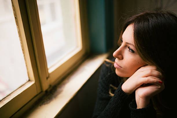istock Young and attractive female looking through window 531046131
