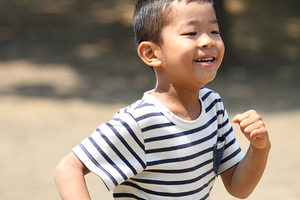Japanese boy running on the grass　(first grade at elementary school)