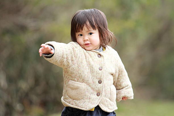 Japanese girl walking on the grass (1 year old)