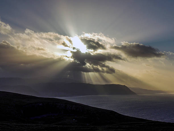 istock Sunshine from behind the clouds, the sea and hills 531047498