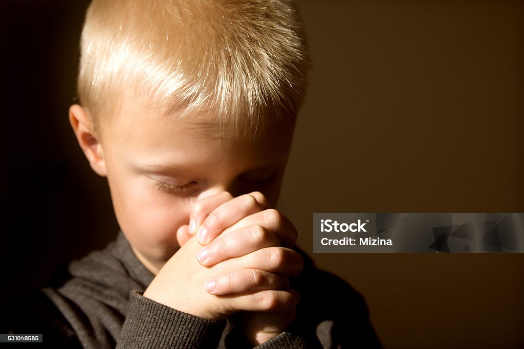 Praying child Little young beautiful boy (child, kid) spiritual peaceful praying and wishing, horizontal, copy space. Child Stock Photo