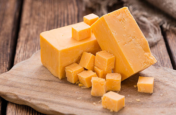 Portion of Cheddar Portion of Cheddar (detailed close-up shot) on vintage wooden background cheddar cheese photos stock pictures, royalty-free photos & images