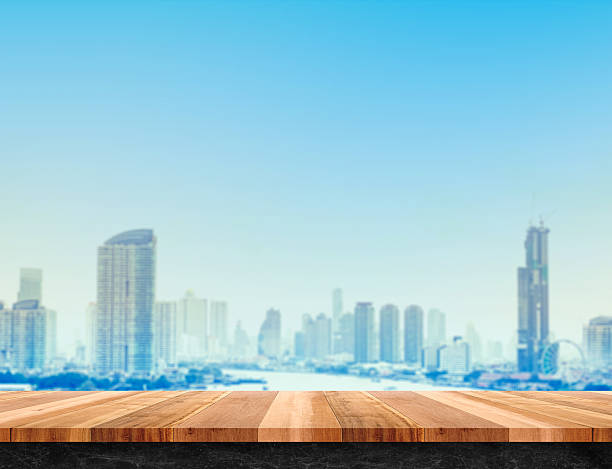 istock wood table top and black marble base with city building 531048928
