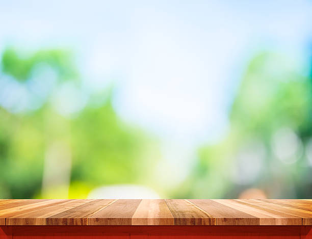 istock Empty brown wood table top with sun and blur tree 531049052