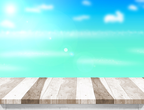 Wood table top with blurred sea,sun and beach at background, Mock up template for display or montage of your product, Summer holiday concept.