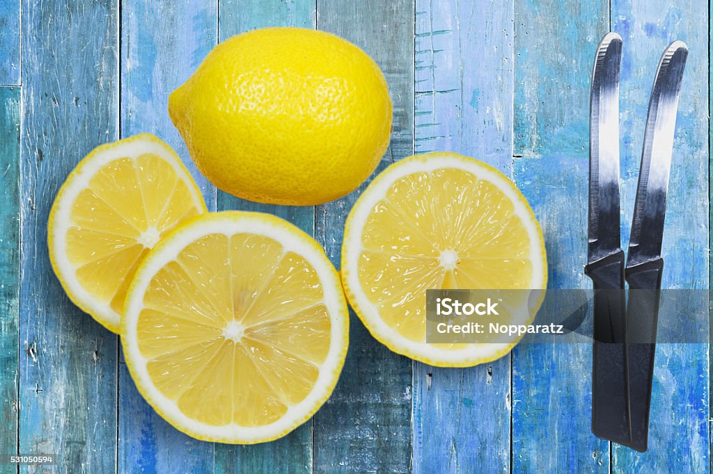 Sliced lemons with knife isolated on blue wood background Sliced lemons with knife isolated on blue wood background. Blue Stock Photo