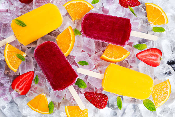 istock refreshing fruit popsicle lollies on ice background with berries, peppermint. 531052114