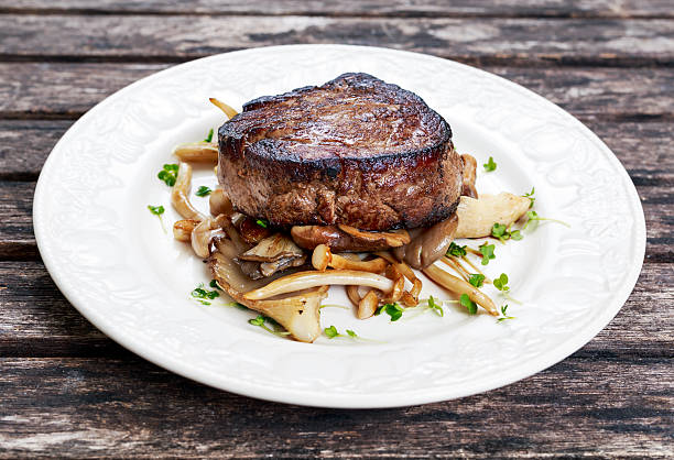 istock Tasty Beef Mignon steak with mushrooms and herbs on plate. 531053058