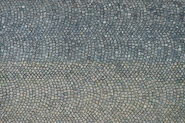 Cobbled Paris street from directly above An overhead view of patterned stone cobbles, making up the surface of an old fashioned Paris street. cobblestone stock pictures, royalty-free photos & images