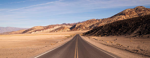 solitario lungo l'autostrada badwater basin della valle della morte - panoramic california mountain range southwest usa foto e immagini stock