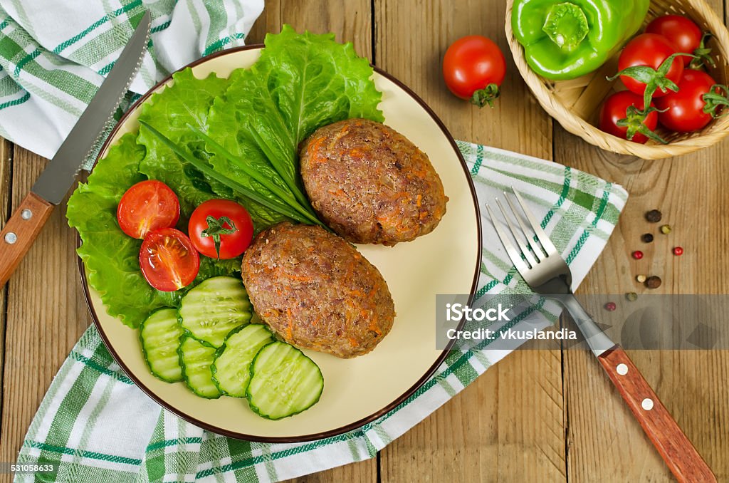 Cutlets with buckwheat and a side dish of vegetables Cutlets with buckwheat and a side dish of vegetables. On the plate are lettuce, cucumbers and tomatoes. 2015 Stock Photo