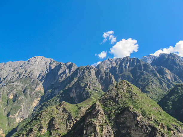 montañas en garganta del salto del tigre. lijiang ciudad, yunnan, china. - jumping ravine tiger sky fotografías e imágenes de stock