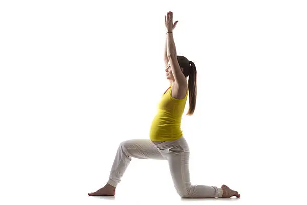 Full length silhouette of young pregnant fitness model in sportswear doing yoga, pilates training, prenatal variation of Warrior I posture, Virabhadrasana 1, white background, studio, isolated