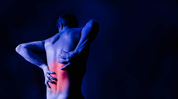 Man holding his back in pain stock photo