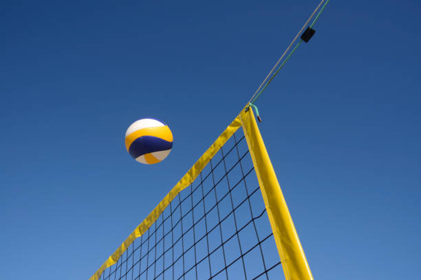 Beach volleyball Beach volleyball personal perspective close-up of net and ball under clear blue sky. Taken with blurred motion and copy space. volleyball net stock pictures, royalty-free photos & images