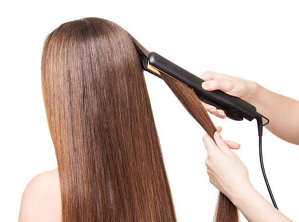 istock Makeup artist aligns long hair Curling on white 531063748
