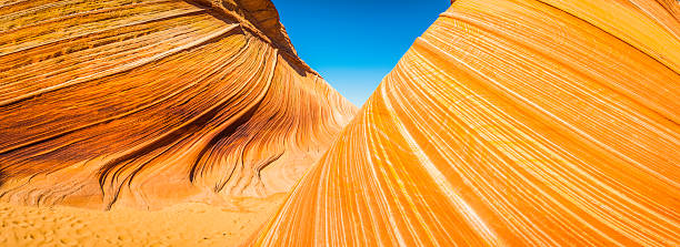 Swirling desert rock strata sandy canyon The Wave panorama Arizona Panoramic view through the vibrant swirling strata and iconic curving canyons of The Wave, the landmark rock formation deep in the Vermillion Cliffs wilderness of Arizona and Utah, Southwest USA. ProPhoto RGB profile for maximum color fidelity and gamut. grand staircase escalante national monument stock pictures, royalty-free photos & images