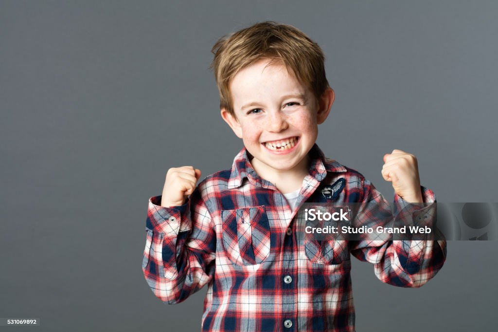 Vincita giovane bambino con dente manca alzare le braccia per divertimento - Foto stock royalty-free di Bambino