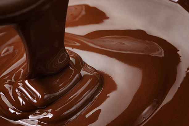 geschmolzener dunkler schokolade flow - chocolate sauce stock-fotos und bilder