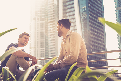 Two friends having conversation outside their office building.