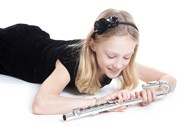 istock young blond girl holds flute lying down in studio 531075233