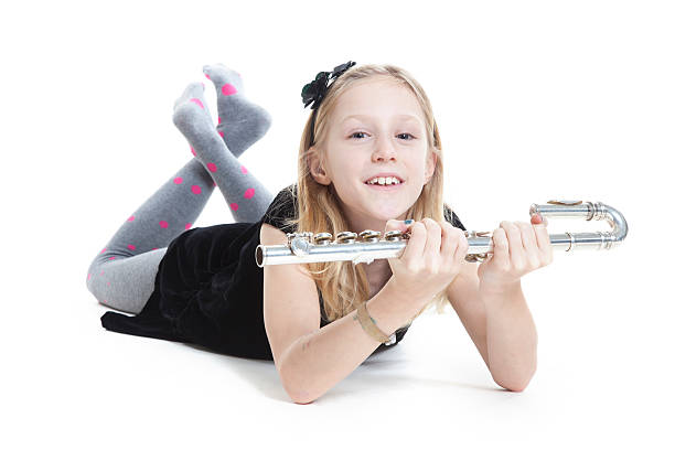 istock young blond girl holds flute lying down in studio 531075267
