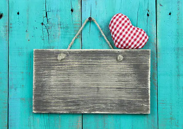 Photo of Blank rustic sign with red heart hanging on wooden background