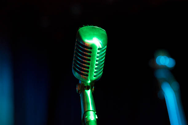 istock Metallic Vintage Microphone on stage in green light 531076833