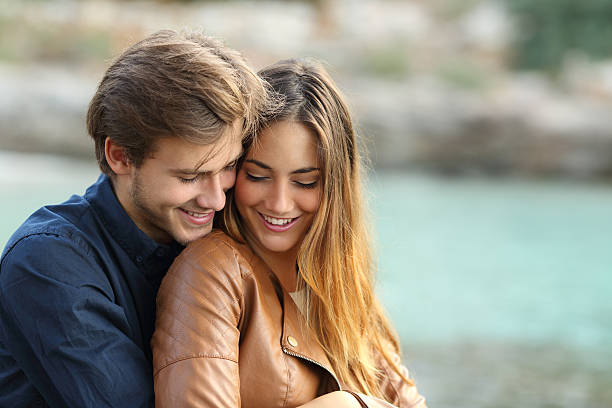 zärtlich paar kuscheln auf den strand - teenage couple stock-fotos und bilder