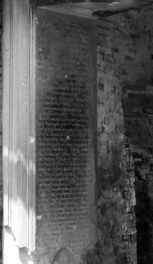 Black and white rendered image of stone tablet containing Sanskrit language located on a temple wall in Cambodia.