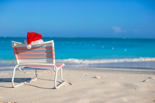 istock Santa hat on chair longue at tropical white beach 531095223
