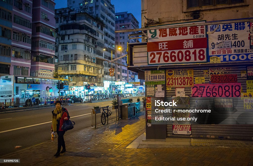 Redevelopment in To Kwa Wan district, Hong Kong Hong Kong, Сhina - December 15, 2014: A woman walks pass a vacant shop in To Kwa Wan district. 2015 Stock Photo