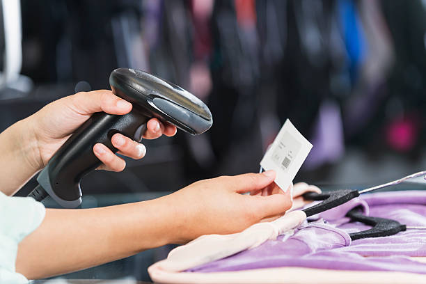 mãos com scanner para procurar etiqueta de preço em loja de roupa - retail occupation cash register retail selling imagens e fotografias de stock