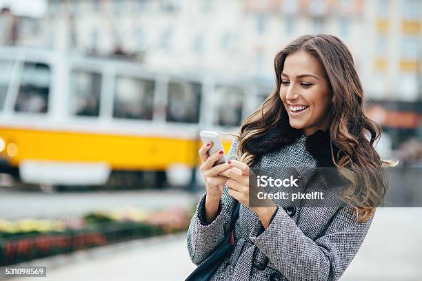 Junge Frau Sms Auf Smartphone Im Freien Stockfoto und mehr Bilder von 2015 - 2015, Am Telefon, Braunes Haar
