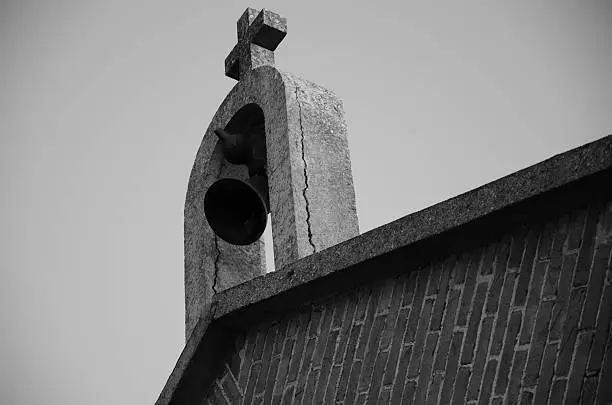 A ringing church bell and cross, black and white
