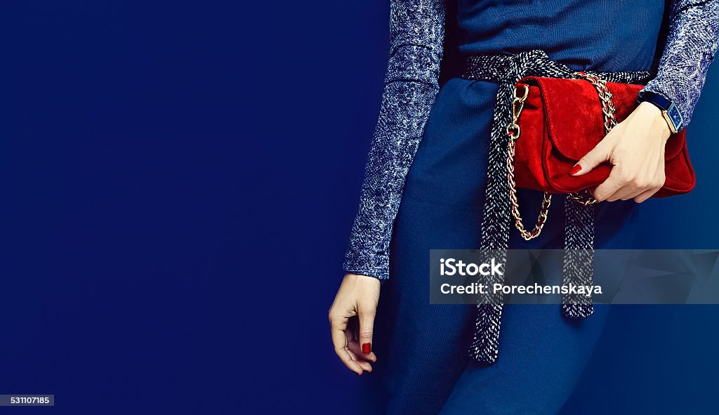 Portrait glamorous lady. Fashion accessories. Watches and red cl Portrait glamorous lady. Fashion accessories. Watches and red clutch on blue background 2015 Stock Photo