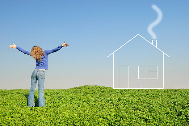 Teen in a wheaten field looks at house