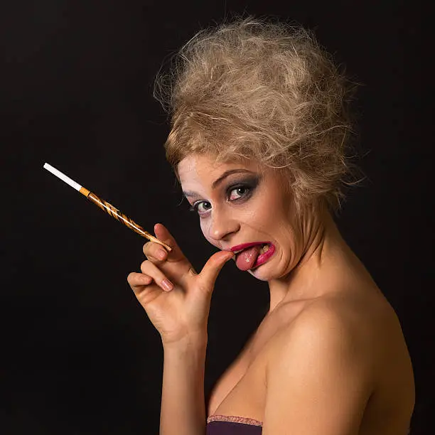 crazy girl with Two-Face makeup and mouthpiece with cigarette studio