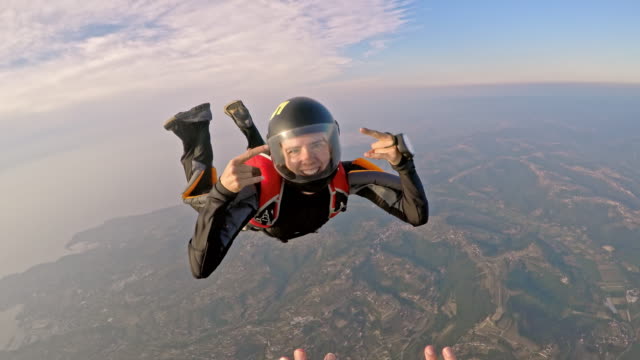 POV Female skydiver sending kisses in air
