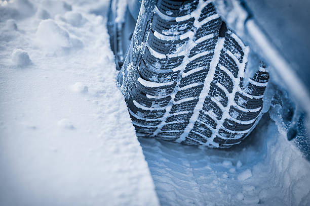 Car tires on winter road stock photo