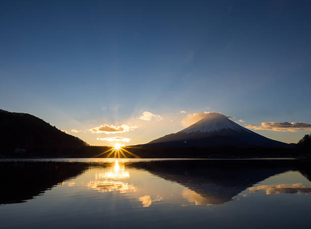 The morning sun rises from ridgeline of Mount Fuji stock photo