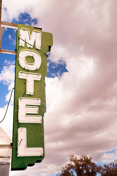 istock Neon Motel Sign Clear Blue Sky White Billowing Clouds 531134237