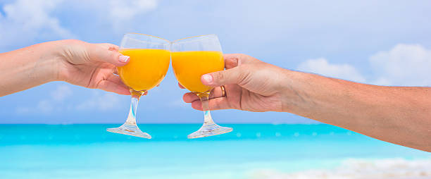 istock Two hands hold glasses background blue sky and turquoise sea 531135237